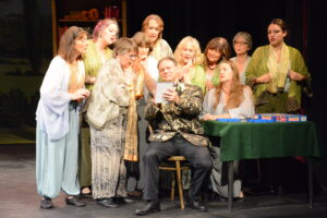 Home A group of women crowding round a man writing poetry
